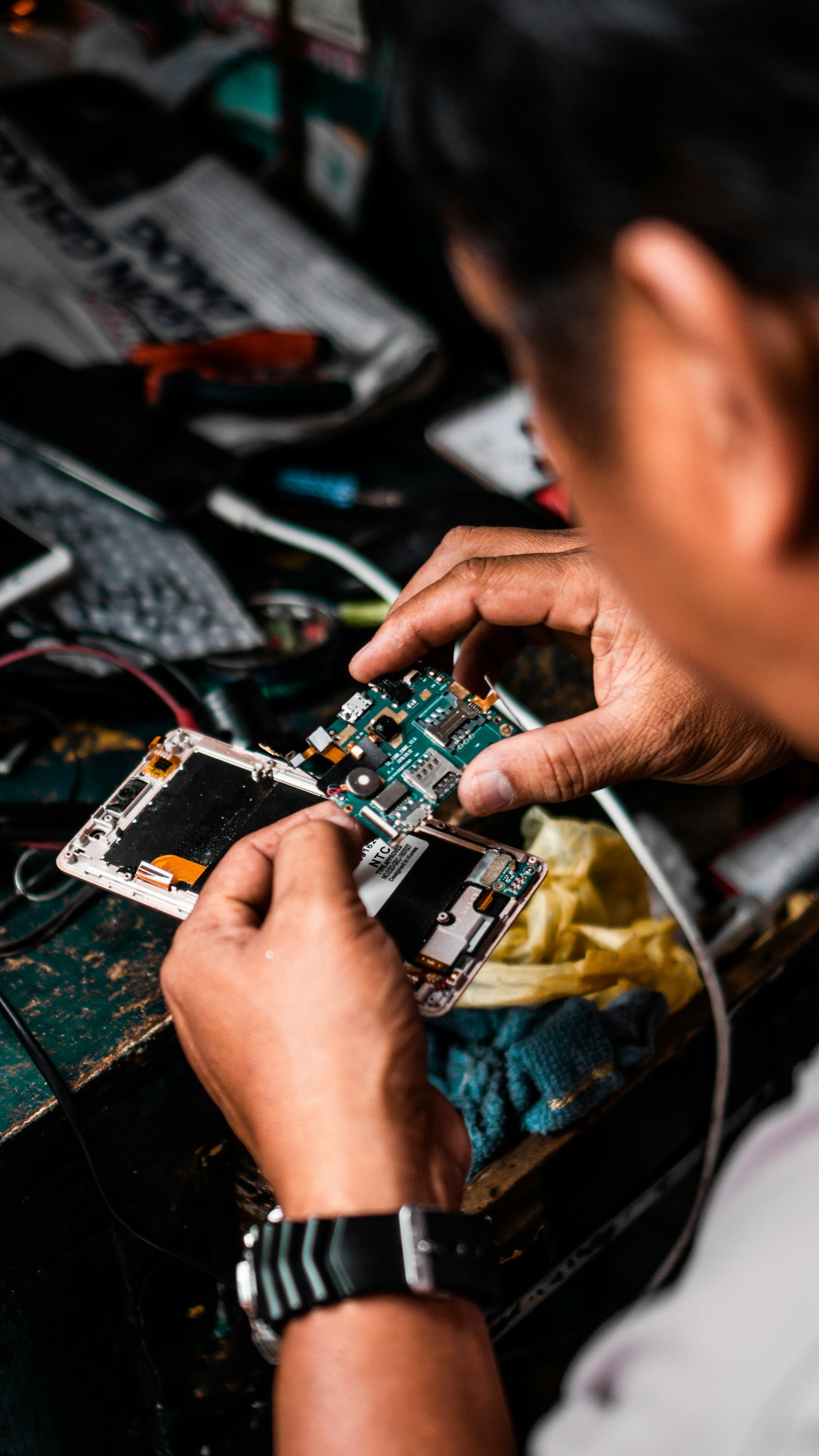 Technician inspecting the components inside a mobile phone